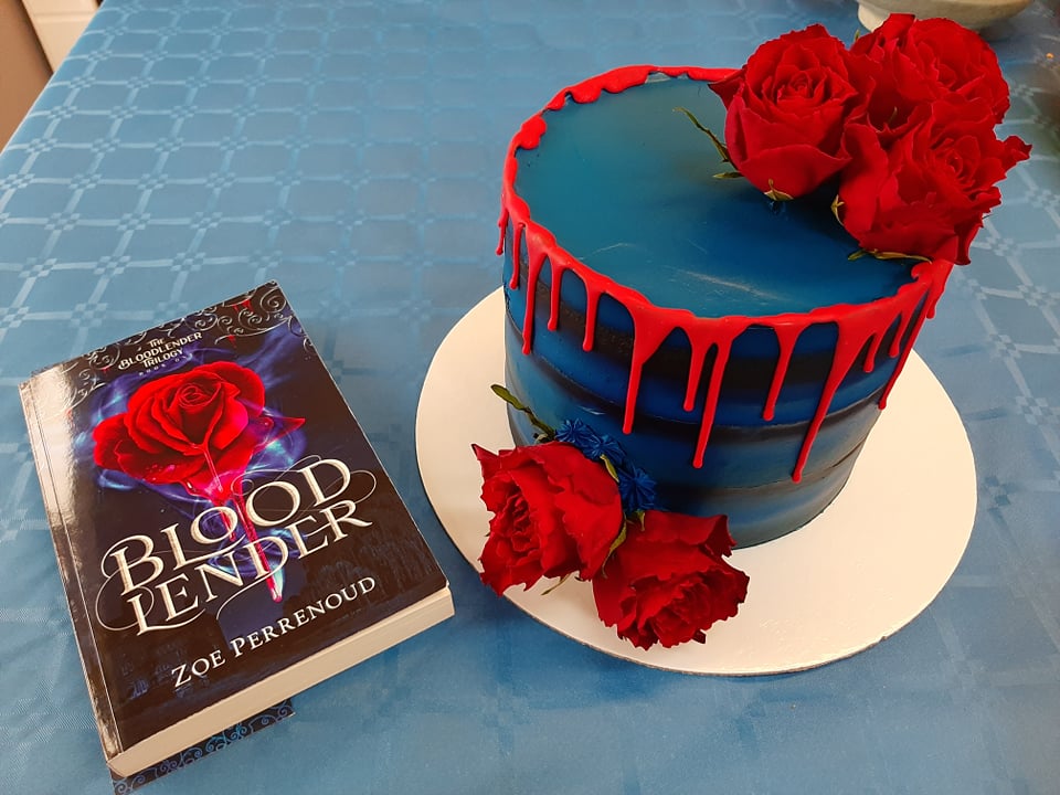 Perrenoud’s first YA novel, Bloodlender, is pictured next to a themed cake from Bakes by Elena, from the book launch in March 2022